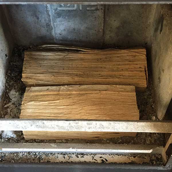 Grote blokken hout onderop om de kachel aan te steken