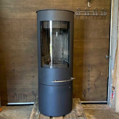 Olsbjerg Tacora Compact gebruikte houtkachel. Hoge ronde haard met gebogen ruit.