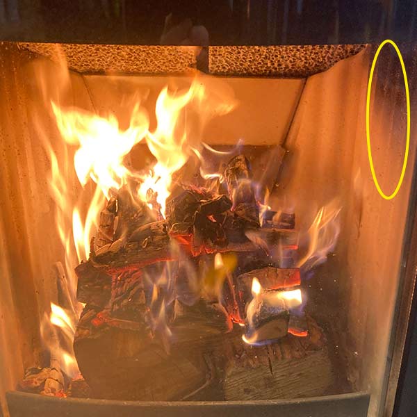Houtkachel brandkamer met vuur en beetje roet aanslag